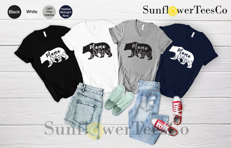 May include: Four V-neck t-shirts with a black bear silhouette and the word "Mama" printed on them. The shirts are in black, white, heather grey, and navy blue.