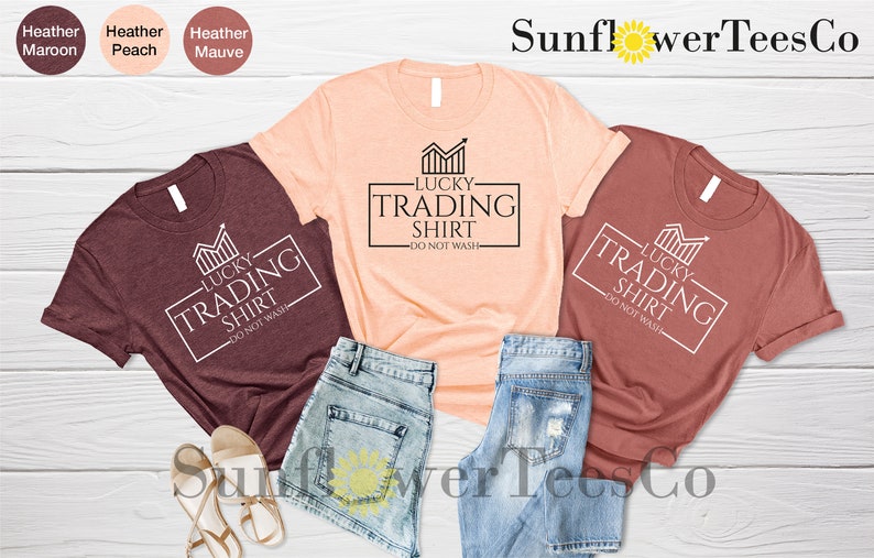 May include: Three t-shirts in different colors, maroon, peach, and rust, with a white graphic that says "Lucky Trading Shirt - Do Not Wash".