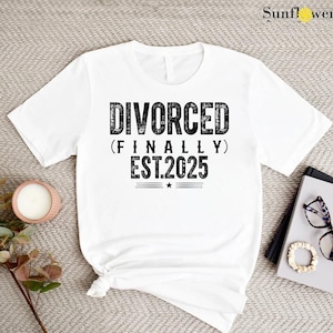 May include: White t-shirt with black text that reads "Divorced (Finally) Est. 2025".