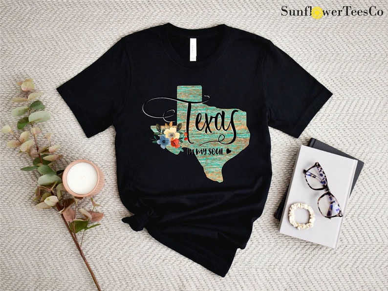 a t - shirt with the word texas on it next to a pair of sunglasses
