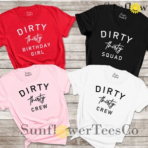 May include: Four t-shirts with the text "DIRTY thirty" in black and white. The shirts are red, black, pink, and white. The text on the red shirt says "DIRTY thirty BIRTHDAY GIRL". The text on the black shirt says "DIRTY thirty SQUAD". The text on the pink and white shirts says "DIRTY thirty CREW".