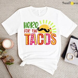 a t - shirt that says here for the tacos