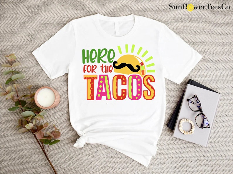 a t - shirt that says here for the tacos