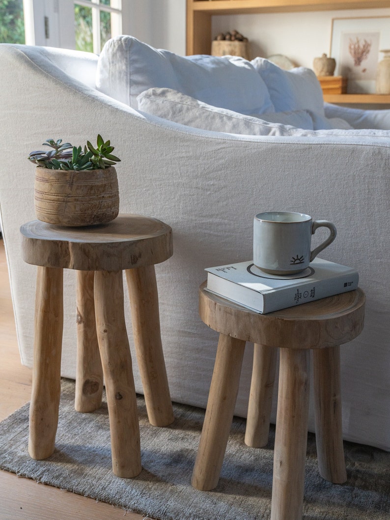 Two teak stools, with coffee mug and honey pot