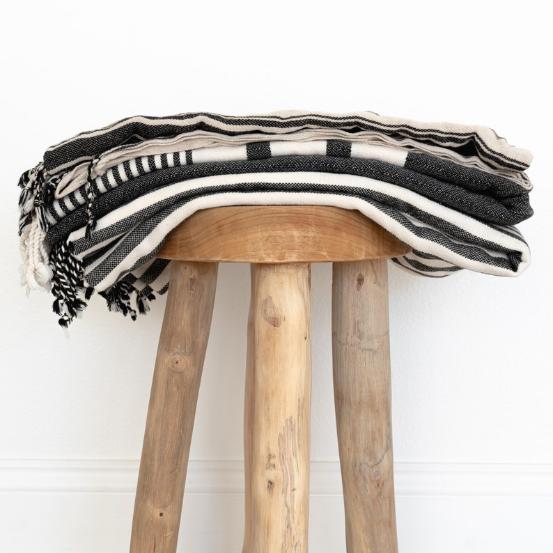 3 turkish towels sitting on a teak stool