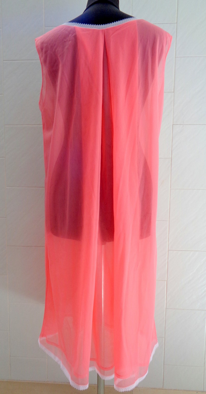 May include: A pink sleeveless slip with a white lace trim around the neckline and hem.
