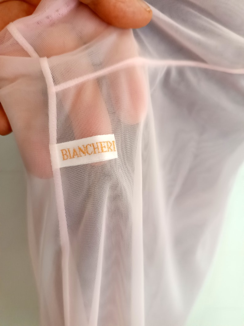 May include: A pale pink sheer fabric with a white label that reads "BIANCHERI".