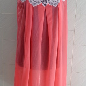 May include: A pink sleeveless nightgown with white lace trim around the neckline.