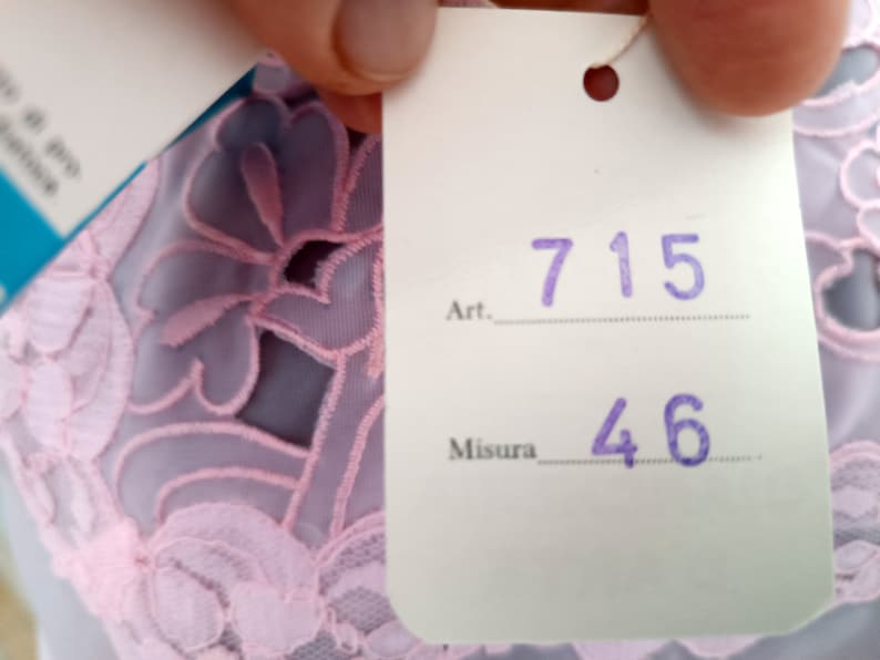 May include: A white tag with purple text, labeled "Art. 715" and "Misura 46".