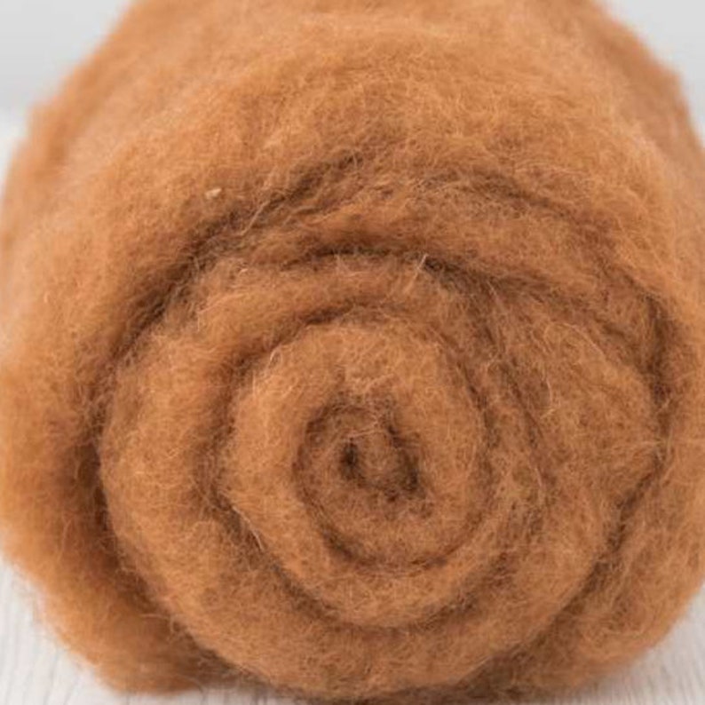 May include: A close-up of a roll of brown wool roving. The wool is soft and fluffy, and it is perfect for felting or spinning.