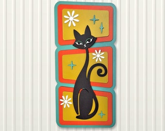 Peut inclure: Une silhouette de chat noir avec une fleur blanche et des étoiles sur un fond turquoise. Le chat est dans un style moderne du milieu du siècle avec une ambiance rétro. L'image est divisée en trois sections avec un fond jaune.