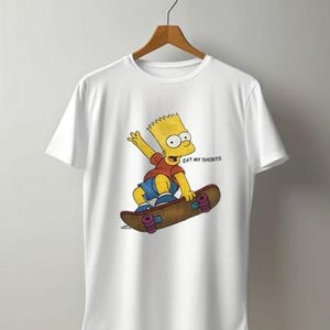May include: White t-shirt with a cartoon image of Bart Simpson on a skateboard. Bart is depicted with yellow hair, a red top, and blue shorts. The text "EAT MY SHORTS" is printed above the skateboard.
