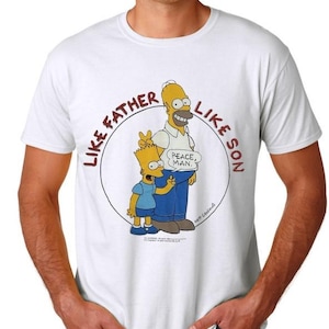 May include: White t-shirt with a circular graphic of Homer and Bart Simpson. The graphic says "Like Father Like Son" and has a speech bubble above Homer that says "Peace, Man."