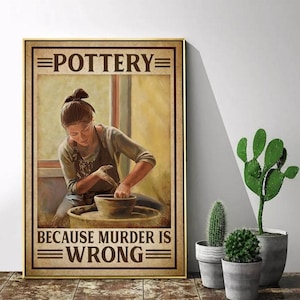 May include: Framed poster with the word "POTTERY" at the top and "BECAUSE MURDER IS WRONG" at the bottom. The image depicts a person working on a pottery wheel. The poster has a gold frame and is displayed near potted cacti.