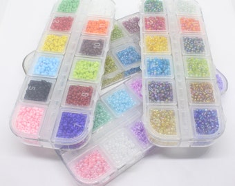 Une petite boîte de 12 couleurs de perles de rocaille en verre 12/0 2 mm. Plus de 3900 perles