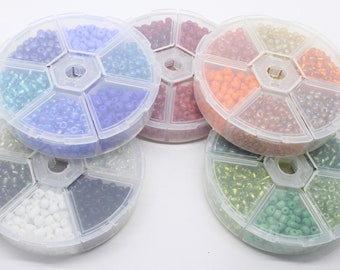 Une petite boîte de perles de rocaille en verre de 4 mm assorties. Environ 700 perles
