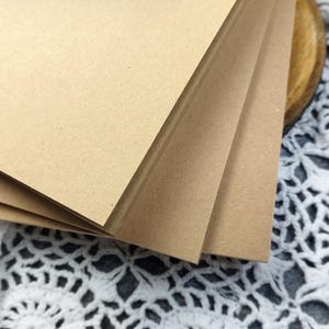 Close-up of the crisp, squared corners of stacked thick kraft cardboard covers. A great handmade book Kit for those who love do it yourself paper projects.