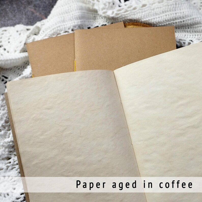 Open notebook featuring beautifully textured, coffee-dyed pages with natural stains. These unique, aged sheets are ideal for creating an authentic junk journal or rustic adventure journal.