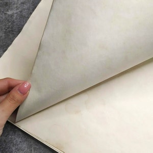 An enlarged image of paper aged in coffee, showing spots that look like natural aging.