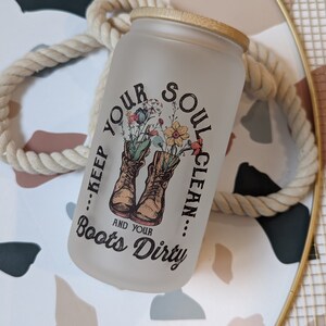 May include: White frosted glass jar with a gold lid and a floral design. The jar has the text "...Keep Your Soul Clean... And Your Boots Dirty" printed on it.