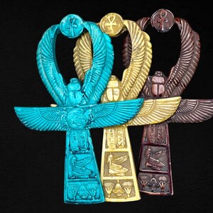 May include: Three Ankh symbols, an ancient Egyptian hieroglyph, in turquoise, gold, and maroon colors. The symbols are intricately detailed with wings, a cross, and a loop at the top.