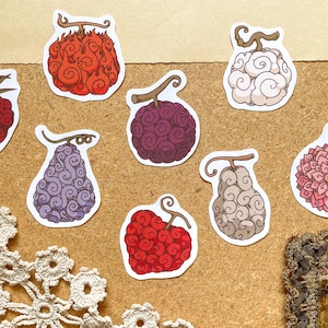 Può includere: Una collezione di adesivi colorati, fustellati, con vari disegni di frutta stilizzati. Gli adesivi presentano una gamma di colori, tra cui rosso, viola e bianco, con motivi e dettagli intricati. Ideale per i fan di anime e manga.