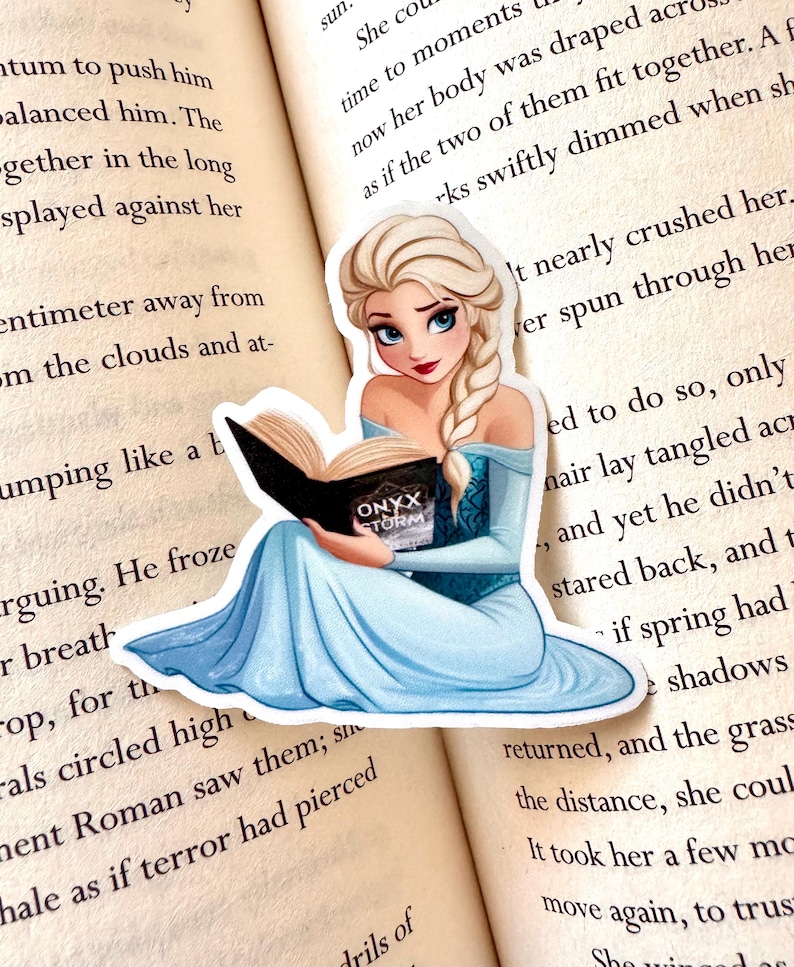 May include: A sticker featuring a cartoon illustration of a woman with long blonde hair, wearing a blue dress, sitting and reading a book titled "Onyx Storm".
