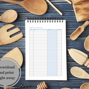 May include: A printable pantry inventory list on a white sheet of paper with blue lines. The paper is in a spiral bound notebook. The notebook is on a blue wooden surface with various wooden kitchen utensils.