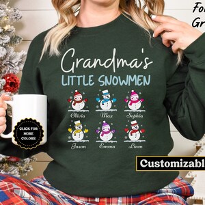 May include: A green sweatshirt with the text "Grandma's Little Snowmen" and a graphic of six snowmen with names below each. The text "Customizable" is at the bottom of the sweatshirt.