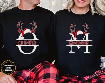 May include: Matching Christmas pajamas with a black background and red and black buffalo plaid accents. The pajamas feature a reindeer with a Santa hat and a personalized monogram with the names "Oliver" and "Madison".
