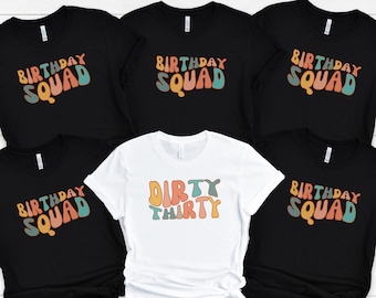 Puede incluir: Cinco camisetas negras con texto blanco y detalles coloridos. Las camisetas dicen "Birthday Squad" y "Dirty Thirty".