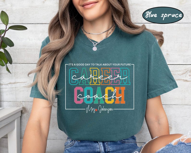 May include: A teal blue t-shirt with the text "It's a good day to talk about your future" above the words "career coach" in colourful block letters. The text "Mrs. Johnson" is below the words "career coach".