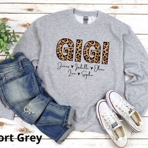 May include: A grey sweatshirt with a leopard print "GIGI" design and the names "James, Isabelle, Olivia, Liam, Sophia" printed below.