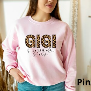 May include: Pink sweatshirt with the word "GIGI" in leopard print letters and the names "James, Isabella, Olivia, Liam, Sophia" written below.