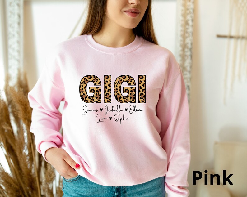 May include: Pink sweatshirt with the word "GIGI" in leopard print letters and the names "James, Isabella, Olivia, Liam, Sophia" written below.