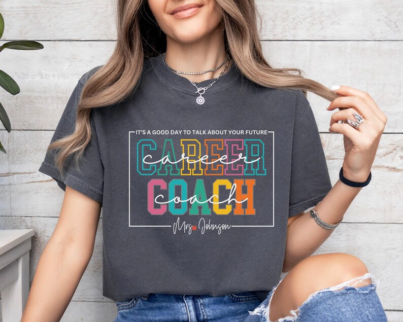 May include: A dark grey t-shirt with the text "It's a good day to talk about your future: Career Coach - Mrs. Johnson" in colourful letters.
