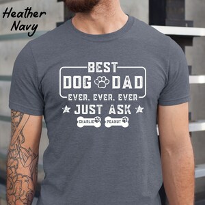 May include: Heather navy t-shirt with the text "BEST DOG DAD EVER. EVER. EVER. JUST ASK". The design includes a paw print and two dog bone graphics with the names "Charlie" and "Peanut".