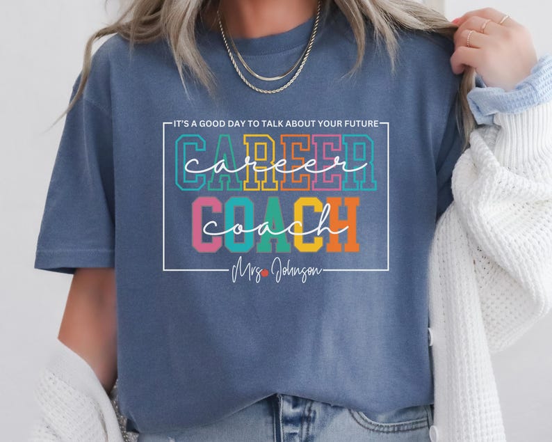 May include: A blue t-shirt with the text "It's a good day to talk about your future" above the text "Career Coach" in rainbow colours. The text "Mrs. Johnson" is below the rainbow text.