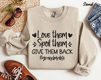 May include: Sand colored sweatshirt with the text "Love them, Spoil them, Give them back #grandmalife" in black. The text is surrounded by small hearts.