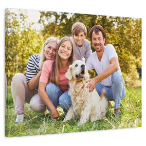 Puede incluir: Impresi&oacute;n en lienzo que muestra a una familia de cuatro y un perro golden retriever, todos sonriendo y posando al aire libre en una zona de c&eacute;sped. La familia viste ropa informal y el perro es de color claro.