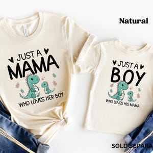 May include: Two cream coloured t-shirts with a dinosaur graphic and text that reads "Just a Mama who loves her boy" and "Just a Boy who loves his mama".