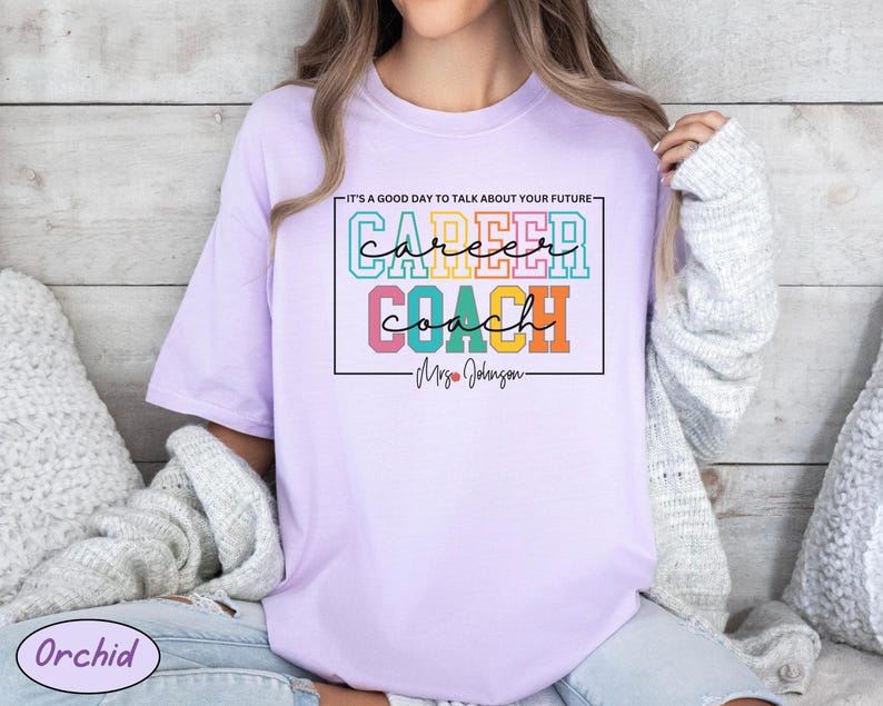 May include: A lavender t-shirt with the text "It's a good day to talk about your future - Career Coach - Mrs. Johnson" in colourful block letters.