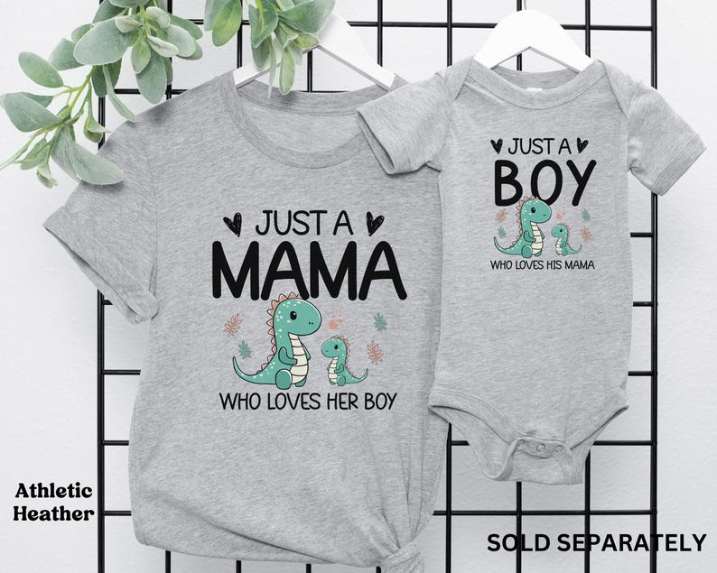 May include: Grey t-shirt with the text "Just a Mama who loves her boy" and a green dinosaur illustration. A matching grey bodysuit with the text "Just a Boy who loves his mama" and a green dinosaur illustration.