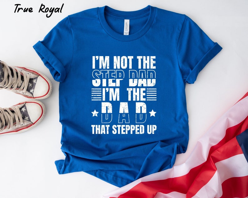 Puede incluir: Camiseta azul con texto blanco que dice "No soy el padrastro, soy el padre que dio un paso adelante".