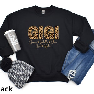 May include: Black sweatshirt with the word "GIGI" in leopard print letters. The names "James, Isabella, Liam, Sophia" are written below the word "GIGI" in a smaller font.