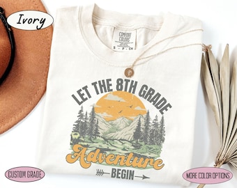 Puede incluir: Camiseta de color marfil con un gráfico de estilo vintage que dice "Let the 8th Grade Adventure Begin" con una escena de montaña y una puesta de sol.