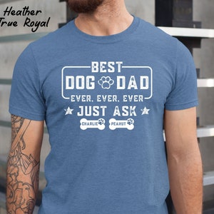 May include: Heather True Royal blue t-shirt with the text "BEST DOG DAD EVER. EVER. EVER. JUST ASK" in white. The shirt includes paw prints and the names "Charlie" and "Peanut" below the text.