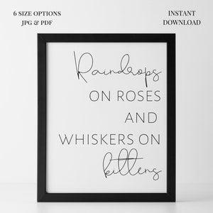 May include: A framed print with the words "Raindrops on Roses and Whiskers on Kittens" in black script. The print is in a black frame and includes the text "6 SIZE OPTIONS JPG & PDF" and "INSTANT DOWNLOAD".