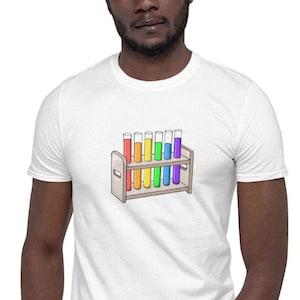 May include: A white t-shirt with a graphic of a rainbow-colored test tube rack. The rack contains 10 test tubes filled with different colors of liquid.