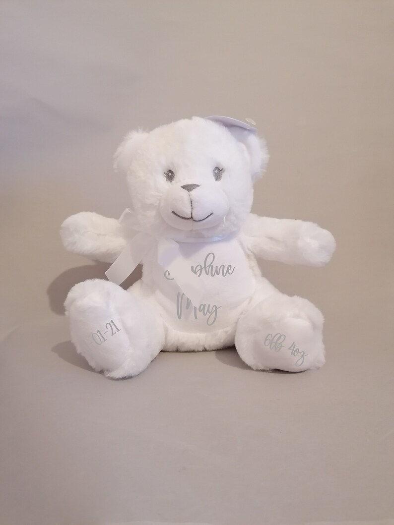 May include: White plush teddy bear with a silver embroidered message that reads "You shine May 01-21 6lb 4oz".
